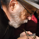 Walter Clevinger blows on the belly of a dusk flycatcher to determine its sex. PHOTO: Courtesy of Paul Kirchner Studios, all rights reserved