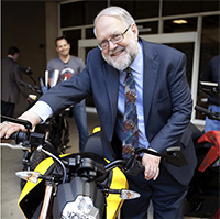 Robert Weisenmiller test-drives a Zero Motorcycle at the Plug-In Electric Vehicle Showcase in 2013.
