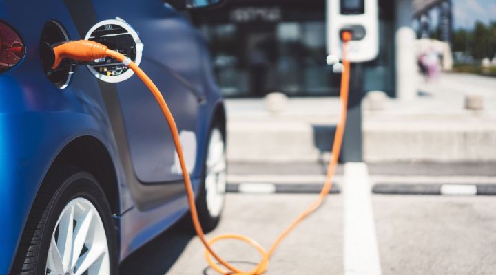 A blue electric car plugged in