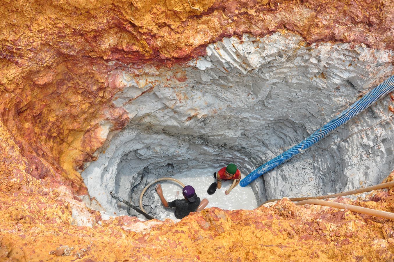 Gold miners in a deep pit