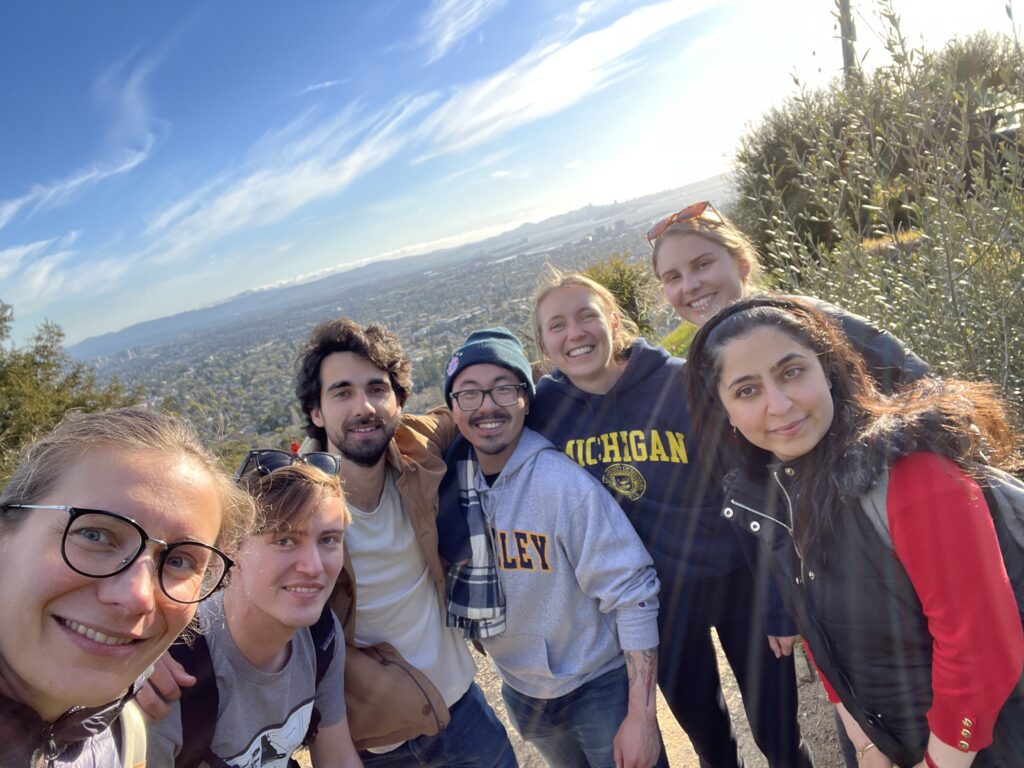 Selfie-style group picture of the lab group with the East Bay in the background.
