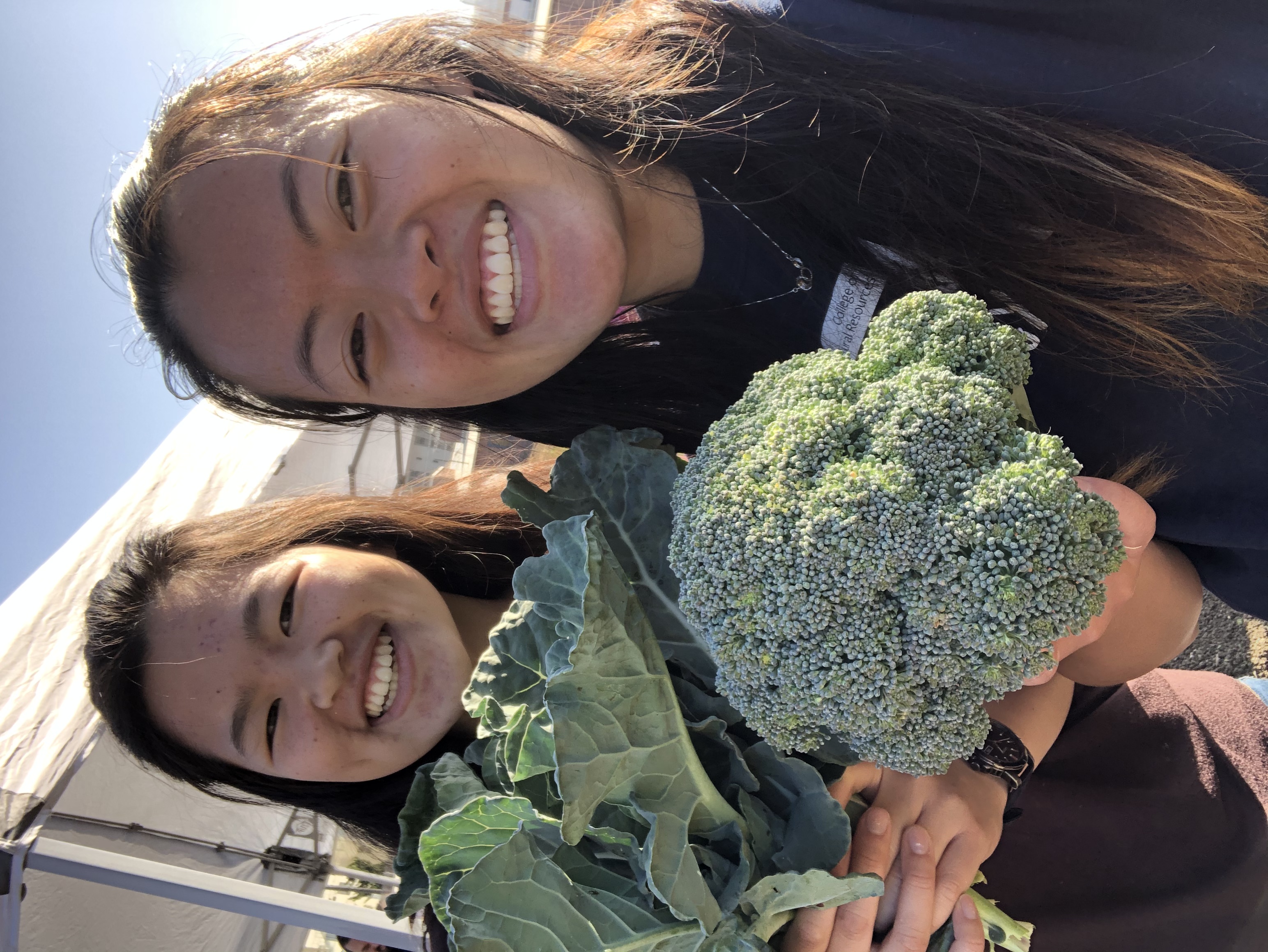 Cho and a friend holding broccoli