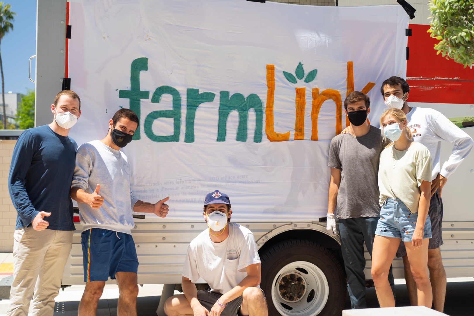 Students smiling and standing around a truck