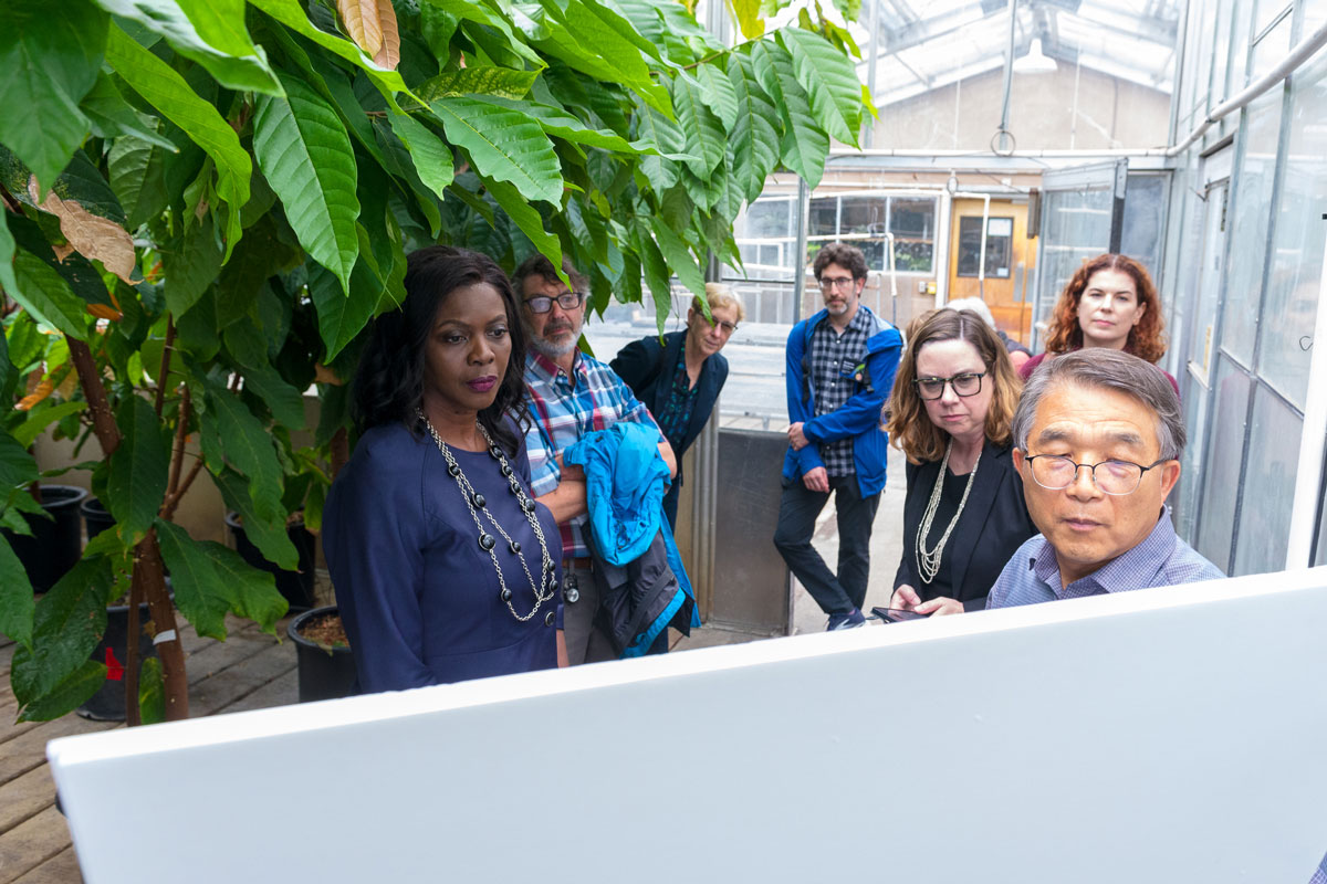 Myeong-Je Cho (right) explains his group’s work on gene editing for disease resistance in cacao plants to Under Secretary Jacobs-Young (far left) and other tour visitors