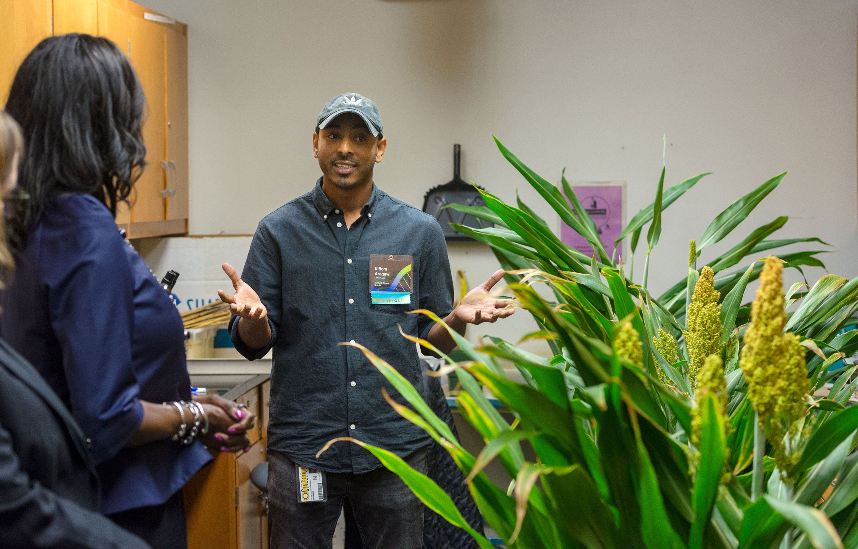 A man talking with a plant in the foreground