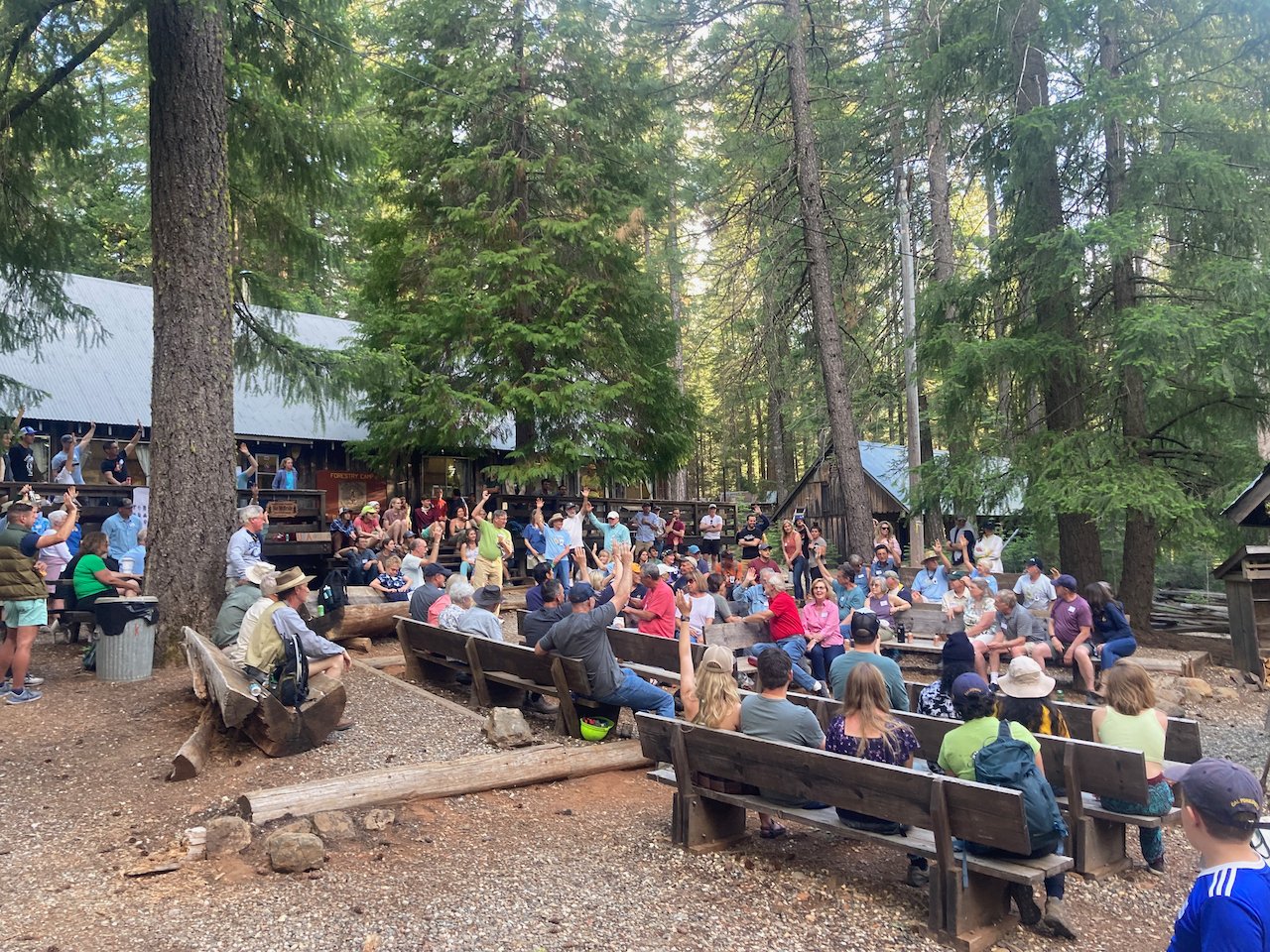 People raise their hands during a photo of the Cal Forestry Field Camp