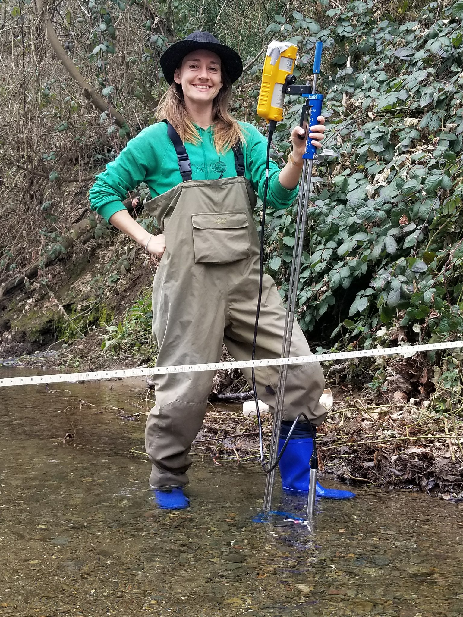 A woman standing in a river conducting research