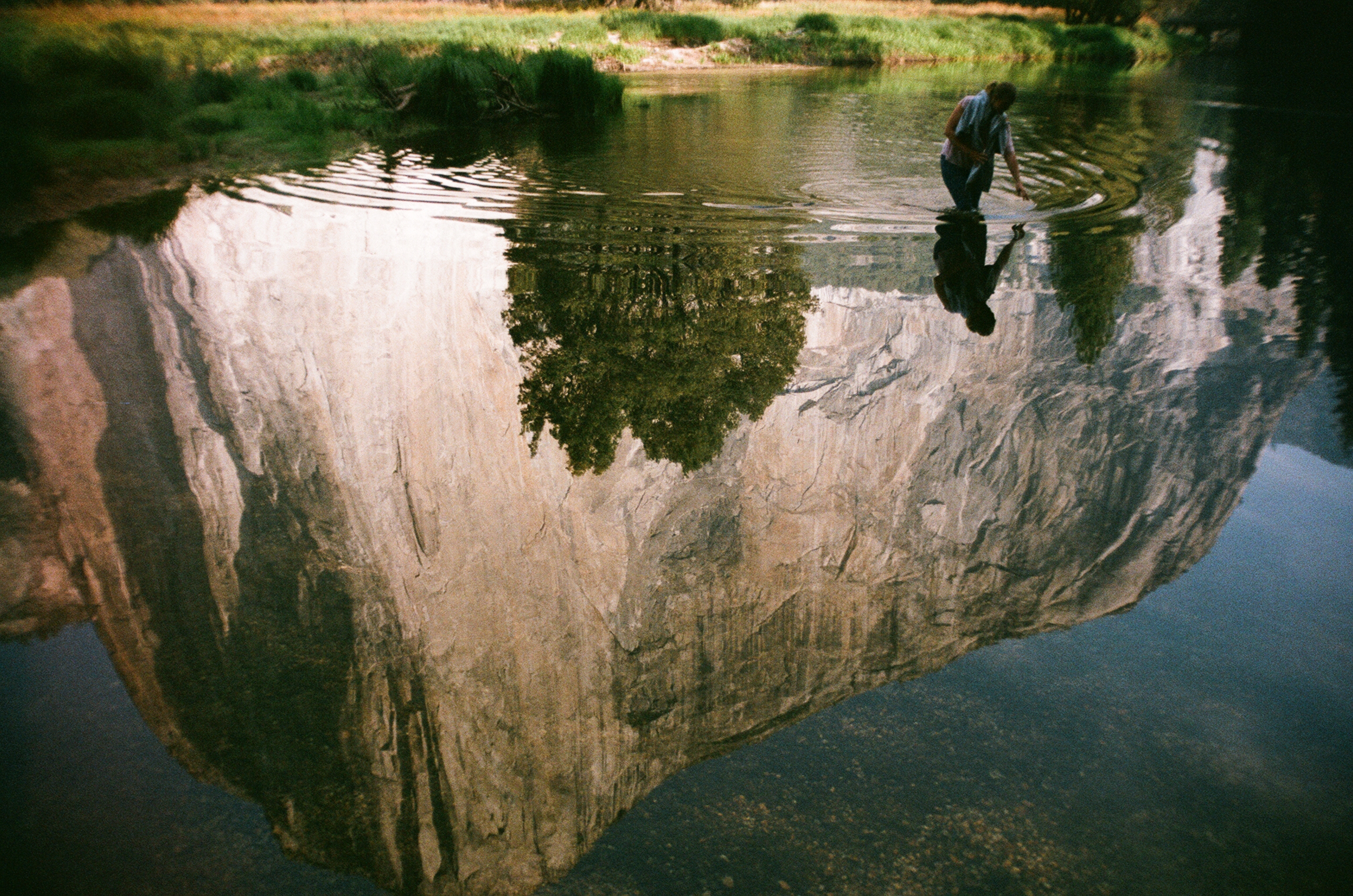 Reflection of a person and a mountain in water