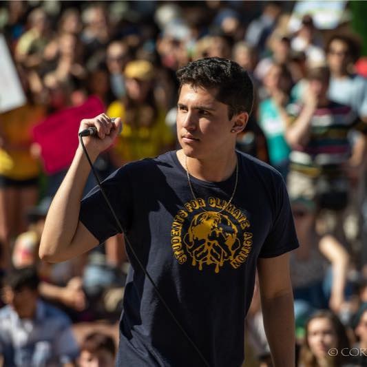 Dante Gonzalez holding a microphone in front of a crowd.