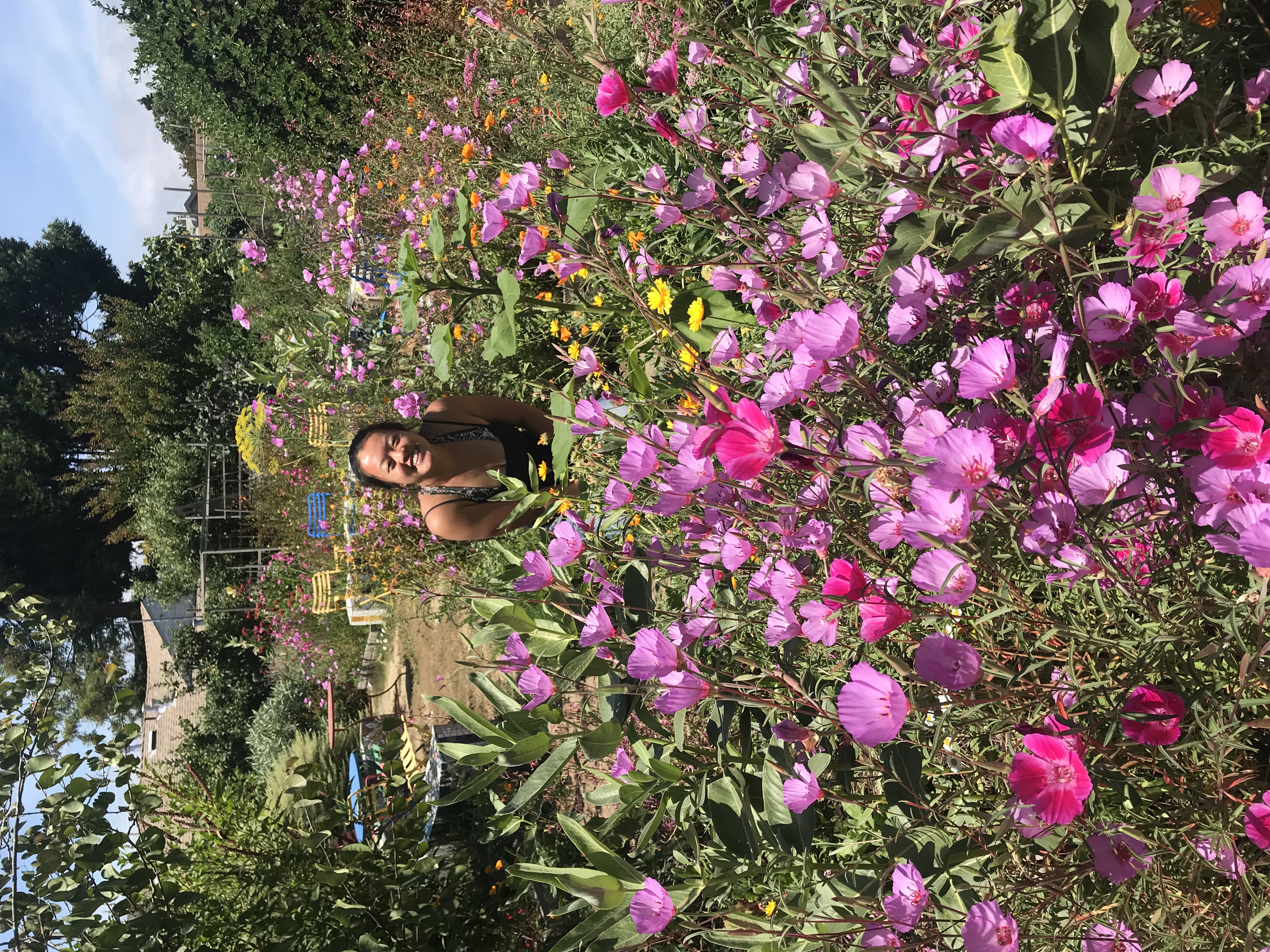 Chloe Cho standing behind planter box filled with flowers