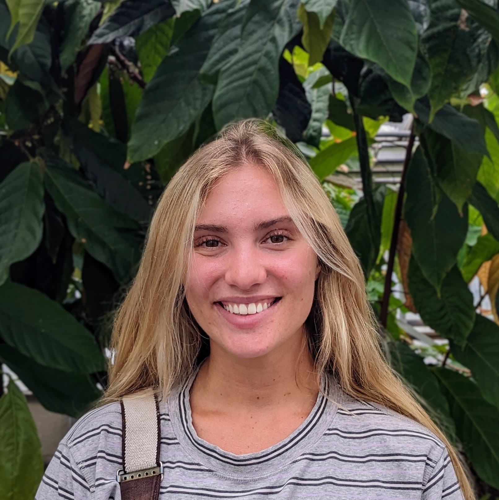 Headshot of a person with plants in the background