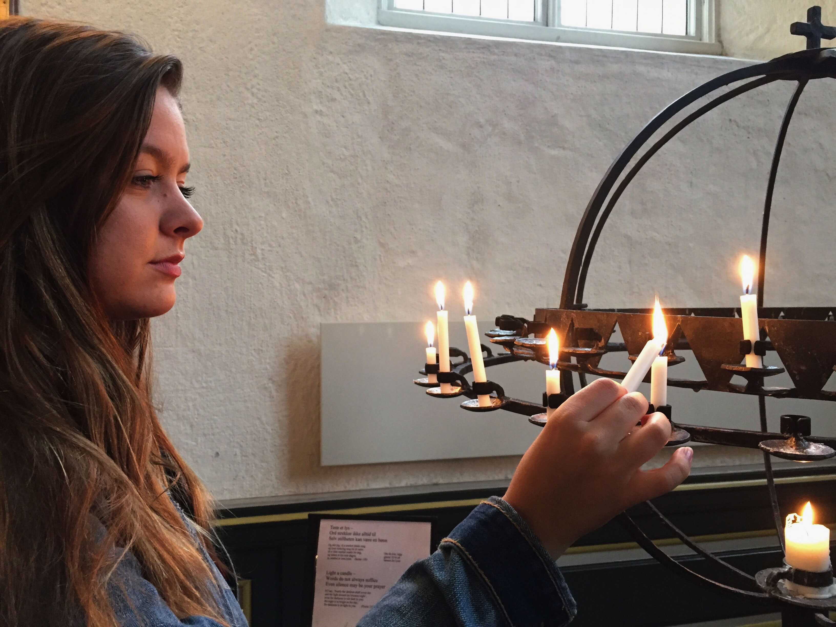 A student lights a candle in a church