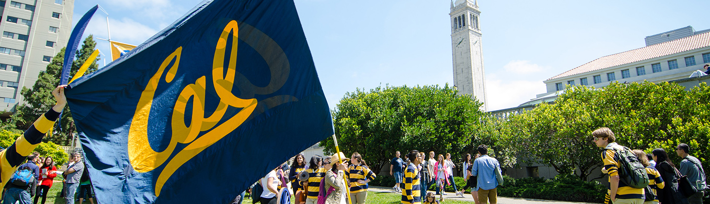 Cal flag and students with the UC Berkeley Campanile in the background