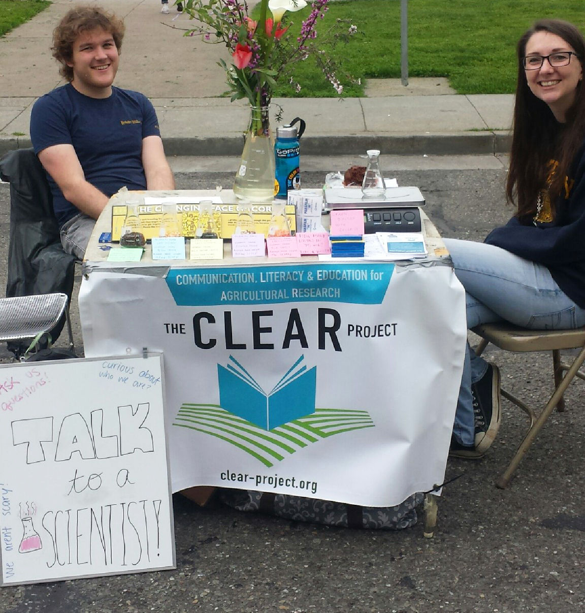 The Clear Project representatives can be found educating the public at the local farmers market with their "talk to a scientist" poster