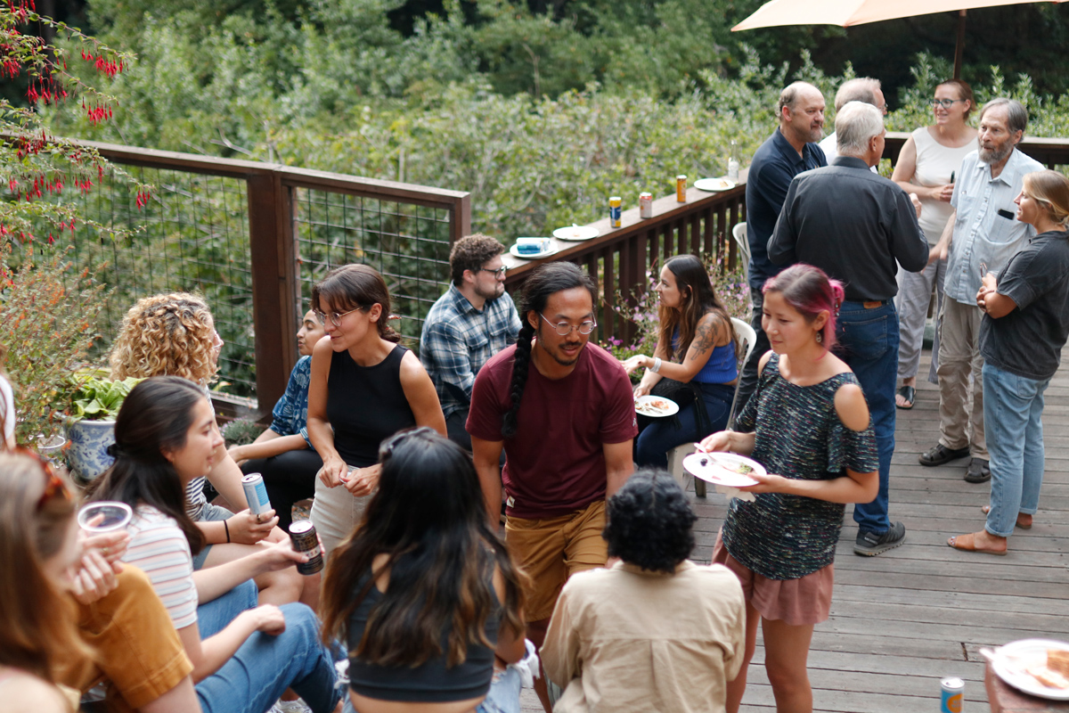 A photo of a group of people standing on a deck during a party.