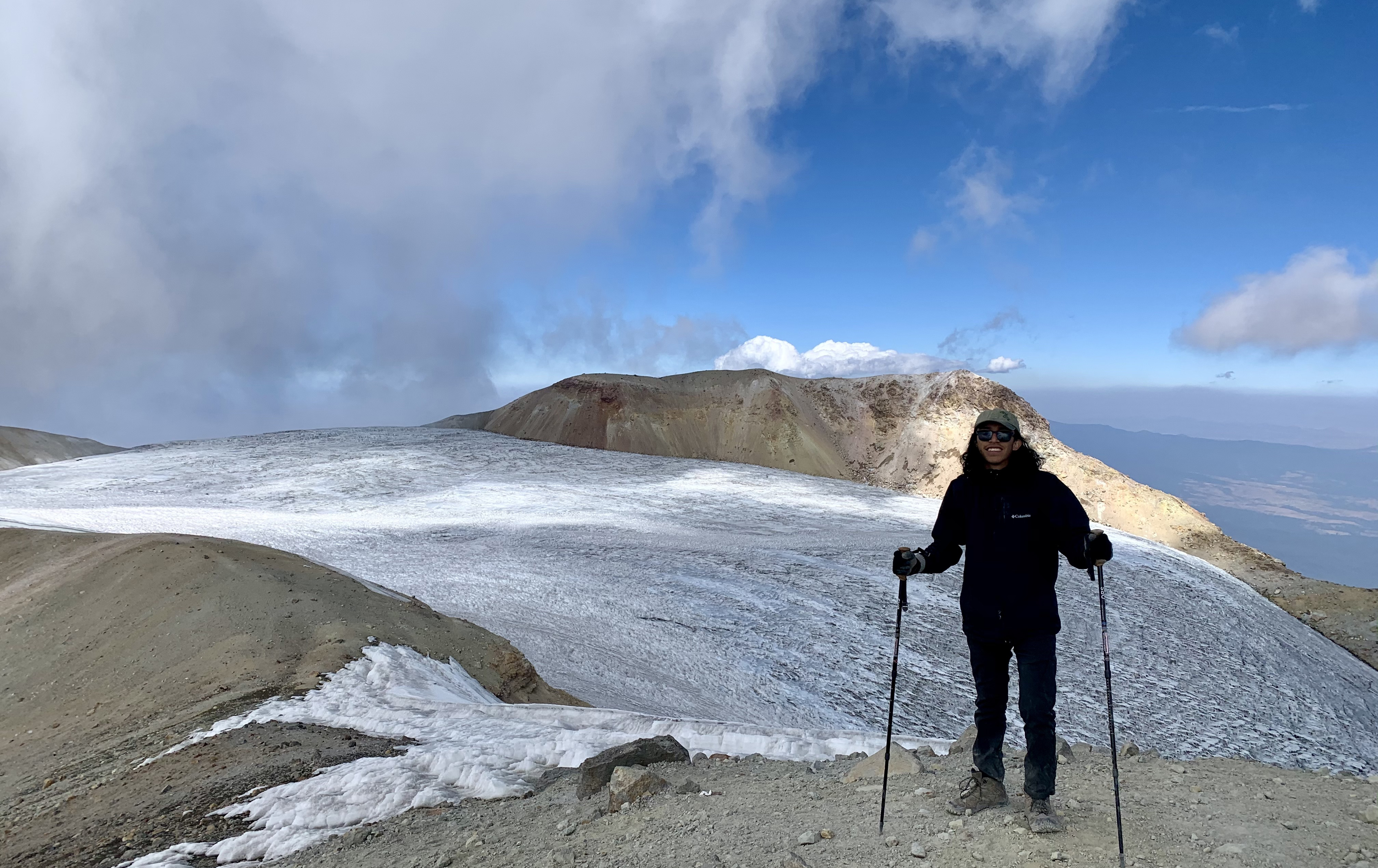 Isaac Aguilar standing with skiis on a mountain