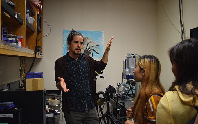 PhD candidate Ignacio Escalante shows the students the high speed cameras and other motion-detecting equipment used by the researchers to study spider behaviors