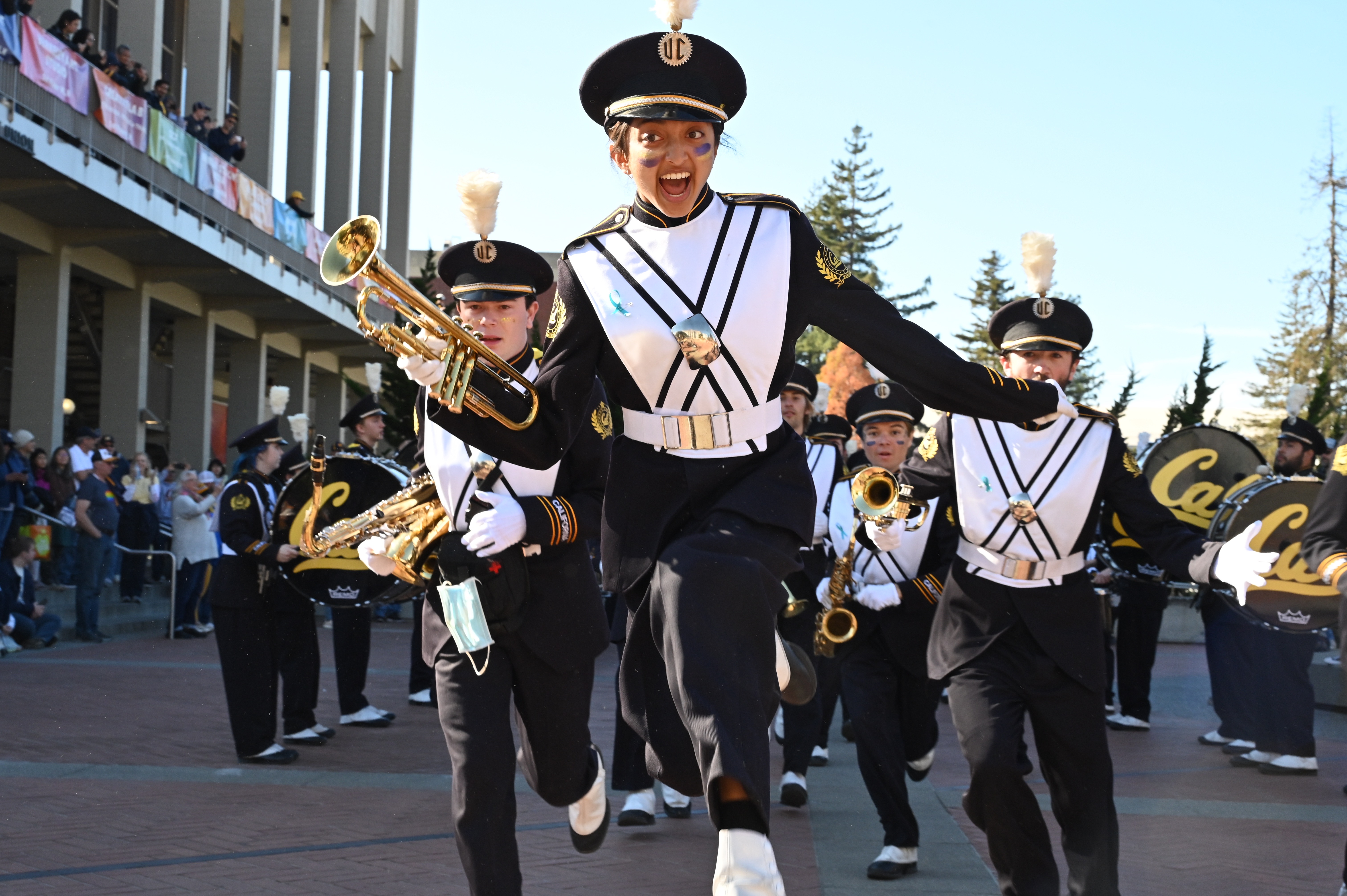 Image of Nikita jumping up in the air in her Cal Band Uniform