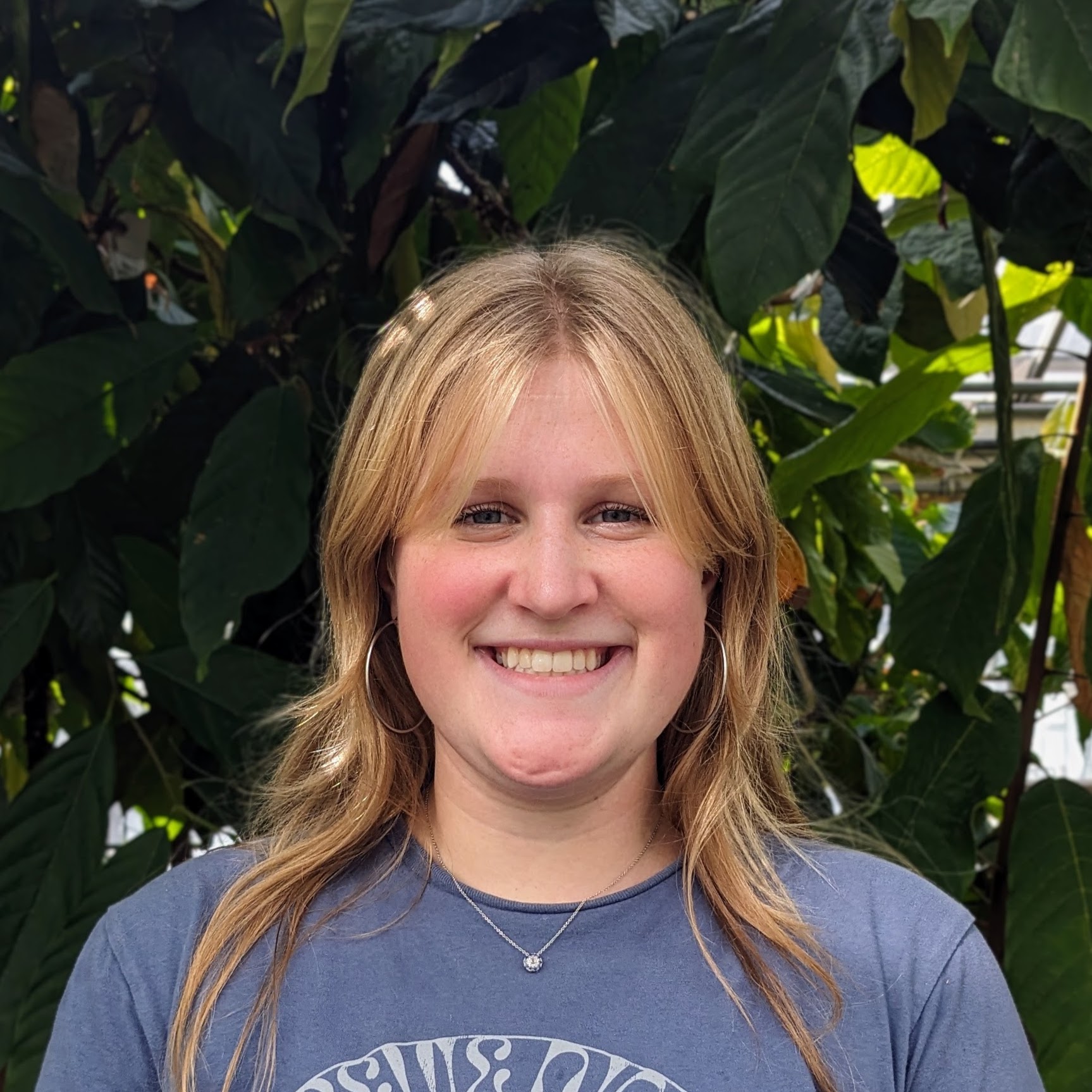 Headshot of person with plants in the background