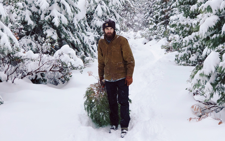 A student trudges through the snow with a cut tree destined for the a previous Cal Forestry Club's annual Christmas tree sale.