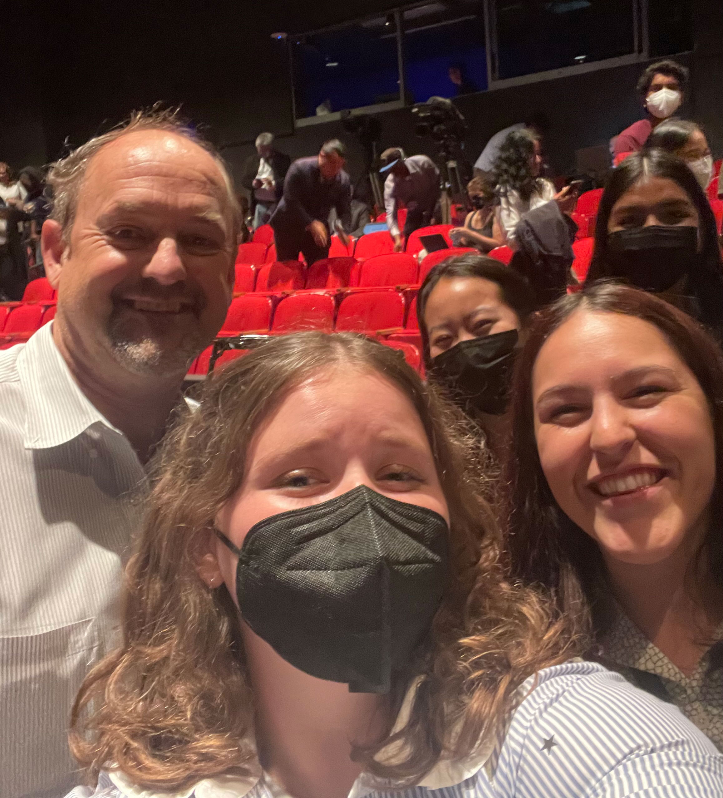 A group of people posing for a selfie in a theater