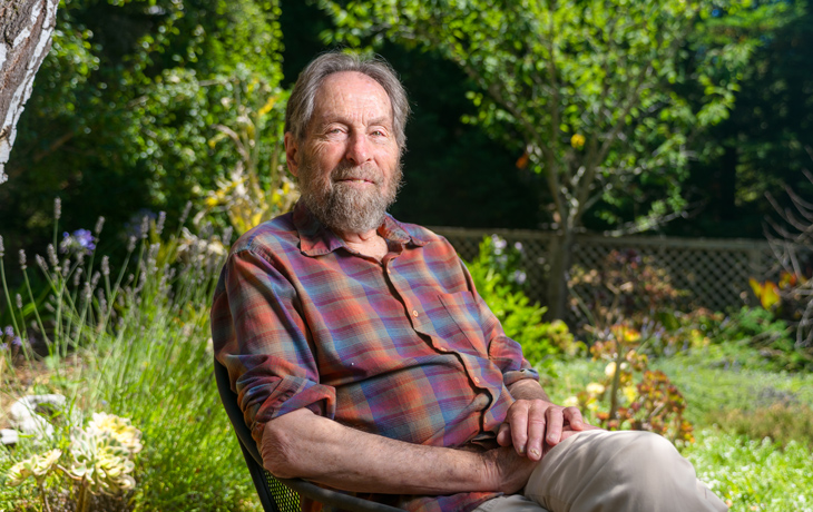 A portrait of John Harte seated in a garden