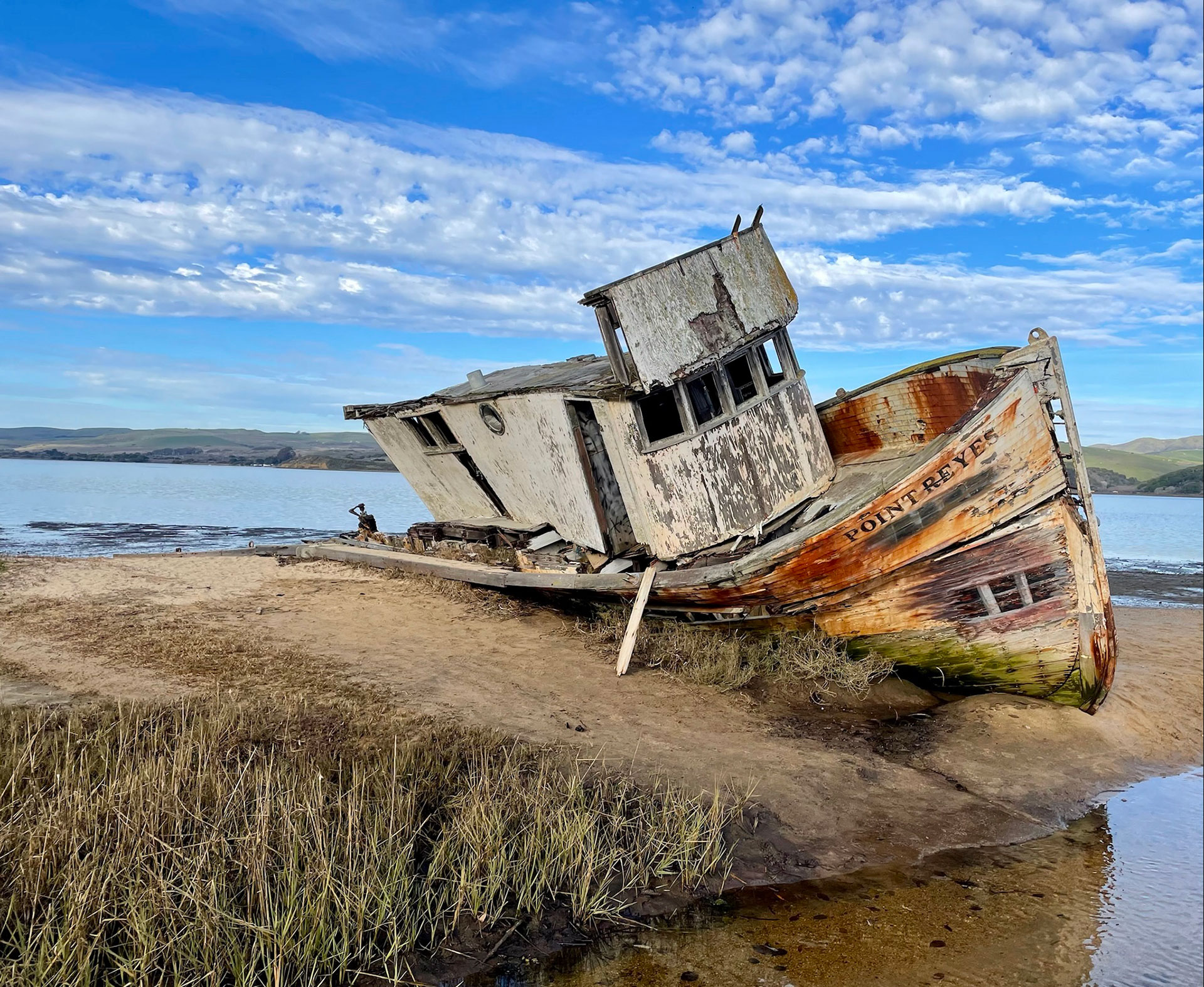 an old shipwreck in front of a bright blue sky