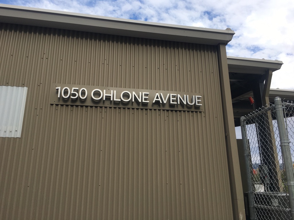 Side of a building with the address '1050 Ohlone Avenue' written on it.