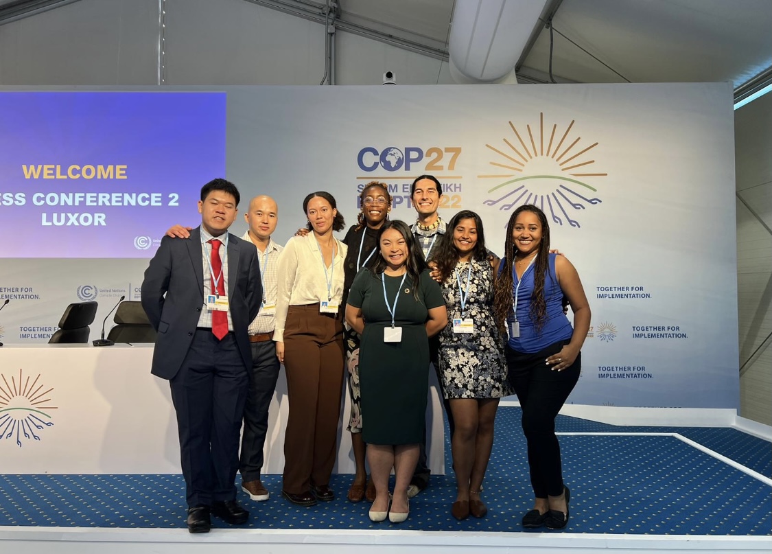 A group of UC Berkeley students stand on a stage at the COP27 conference.