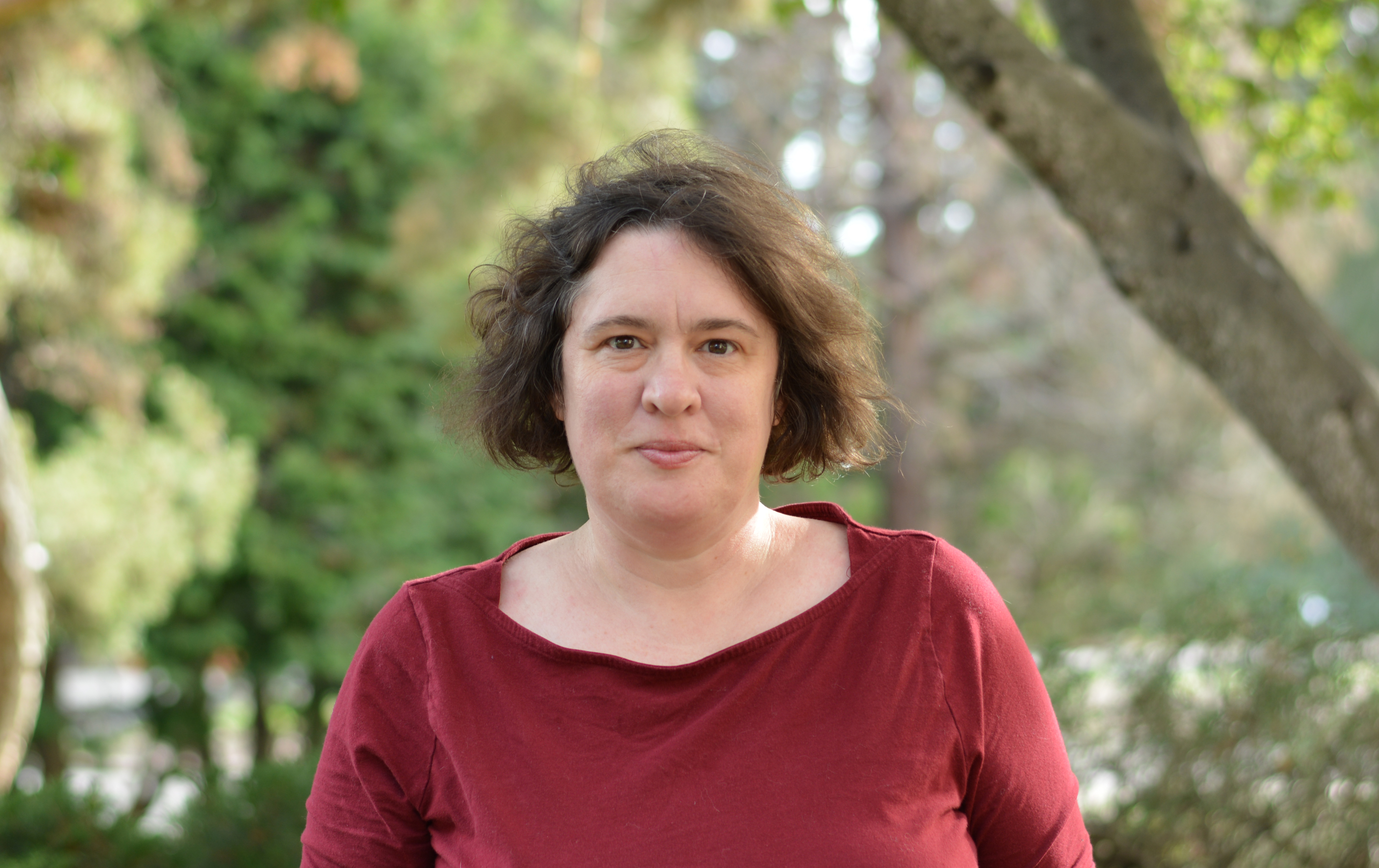 Kate O'Neill standing in front of trees.