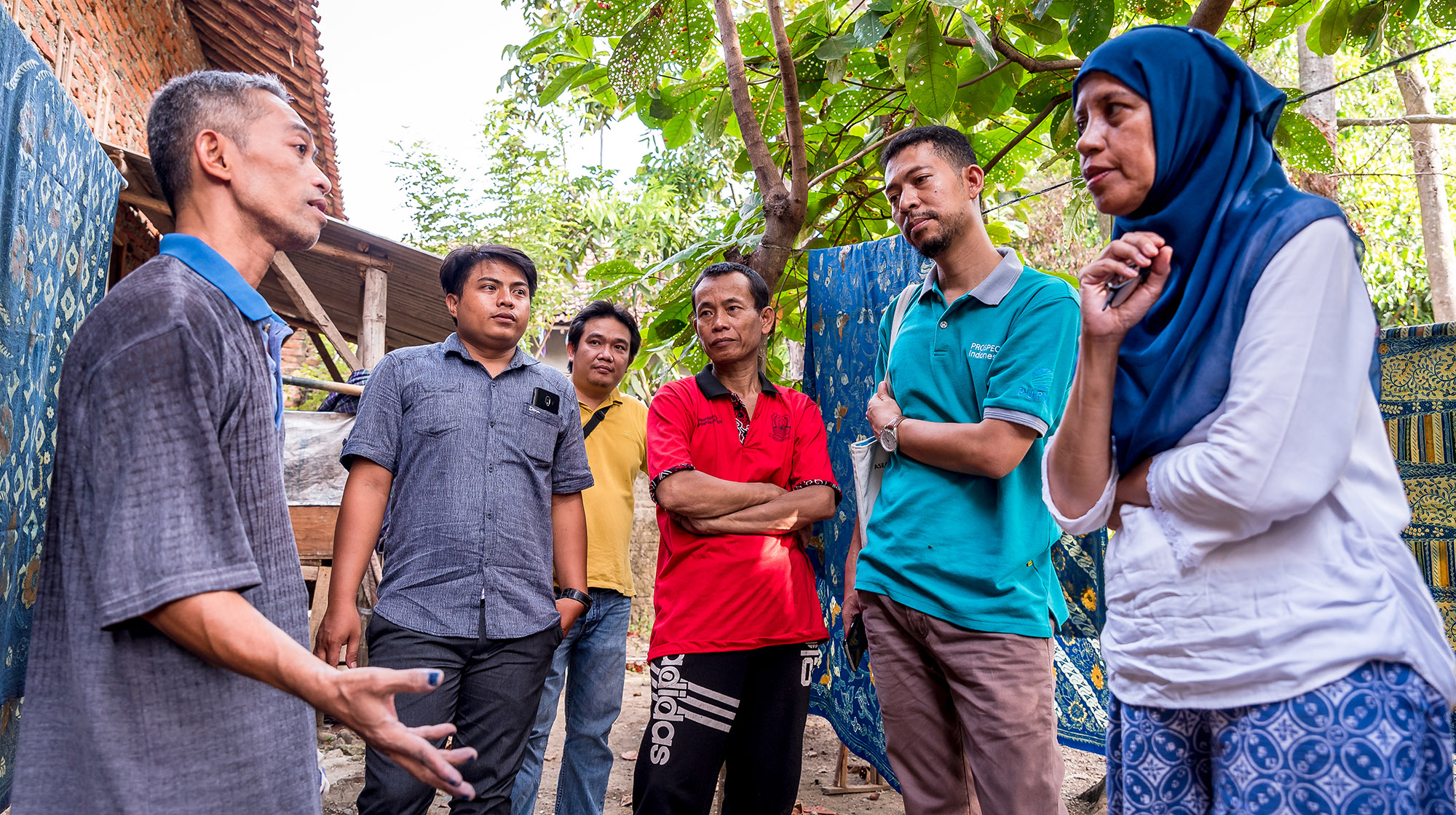 One man speaking to four men and one woman.