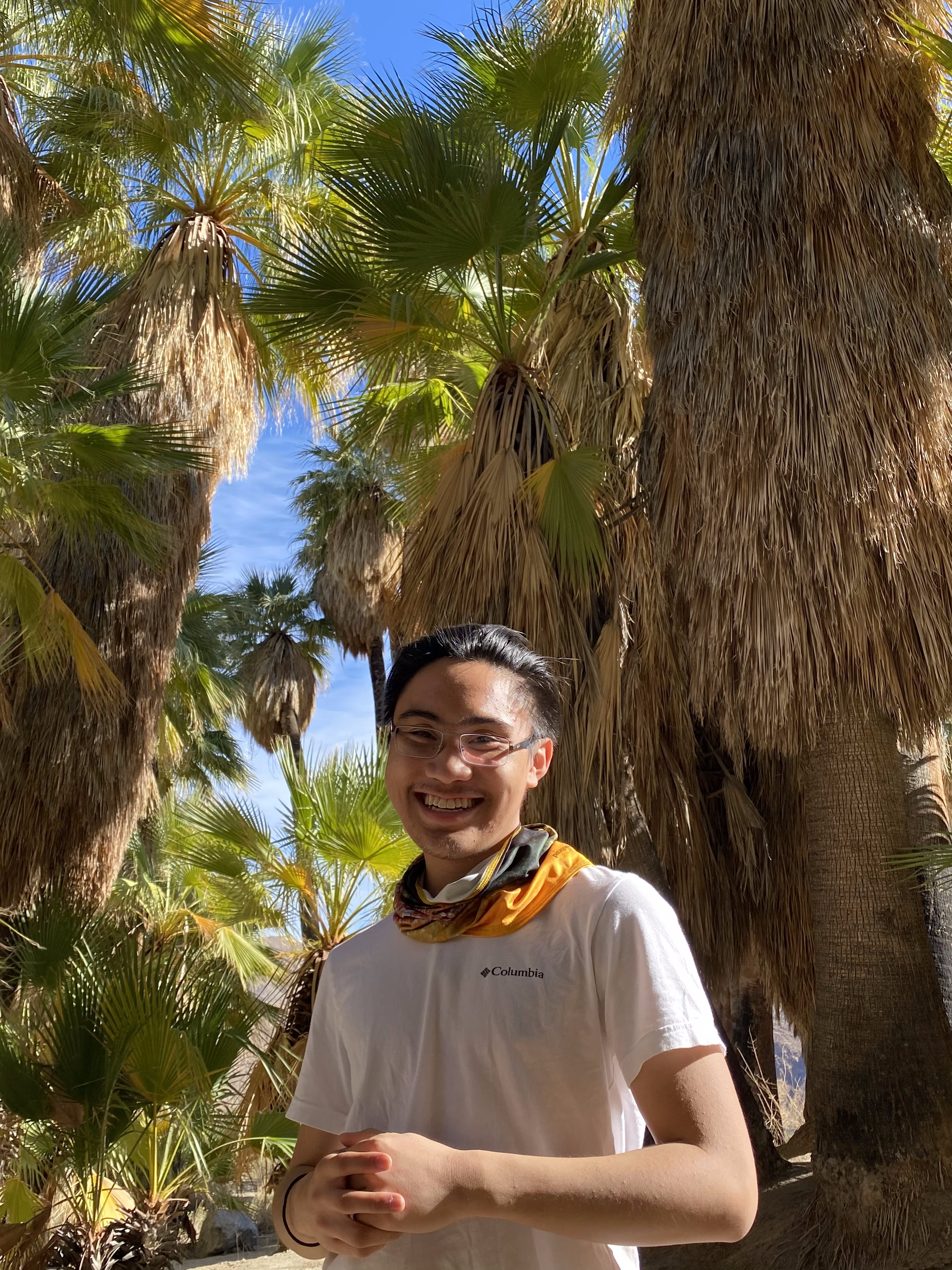 Gerard Legaspi standing under palm trees