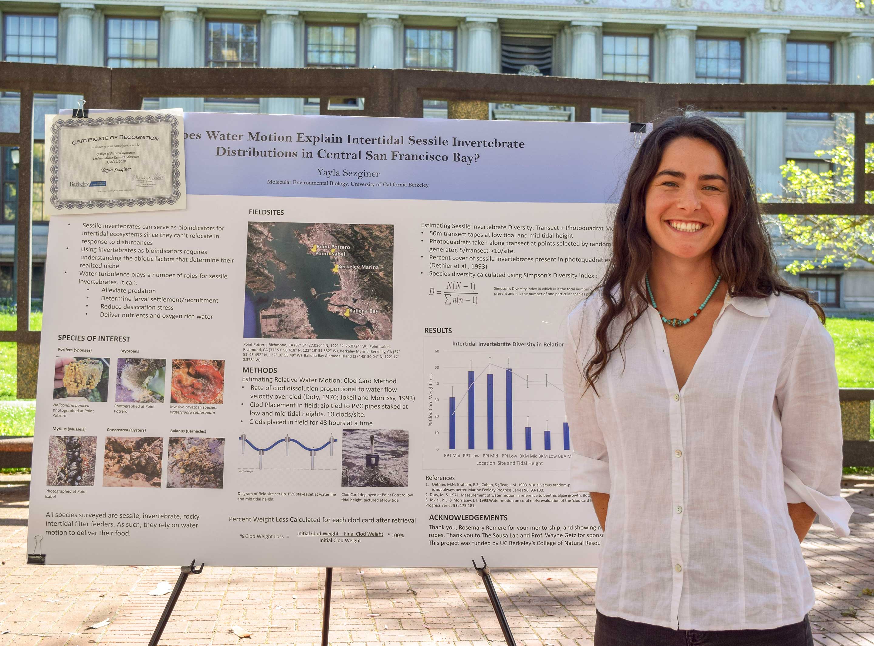 A smiling student and a research poster