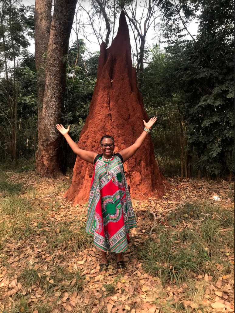 Violet Henderson standing in a forest with her arms up.