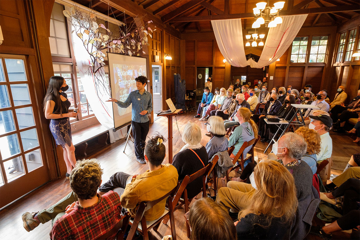 Assistant Professor Benjamin Blonder introduces Juniper Harrower during a closing ceremony for the Botanical Entanglements exhibition at the UC Botanical Garden.