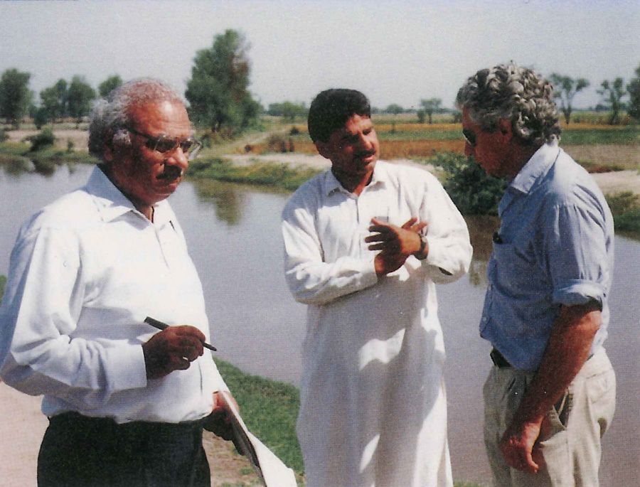 A photo of three men speaking in an outdoor environment