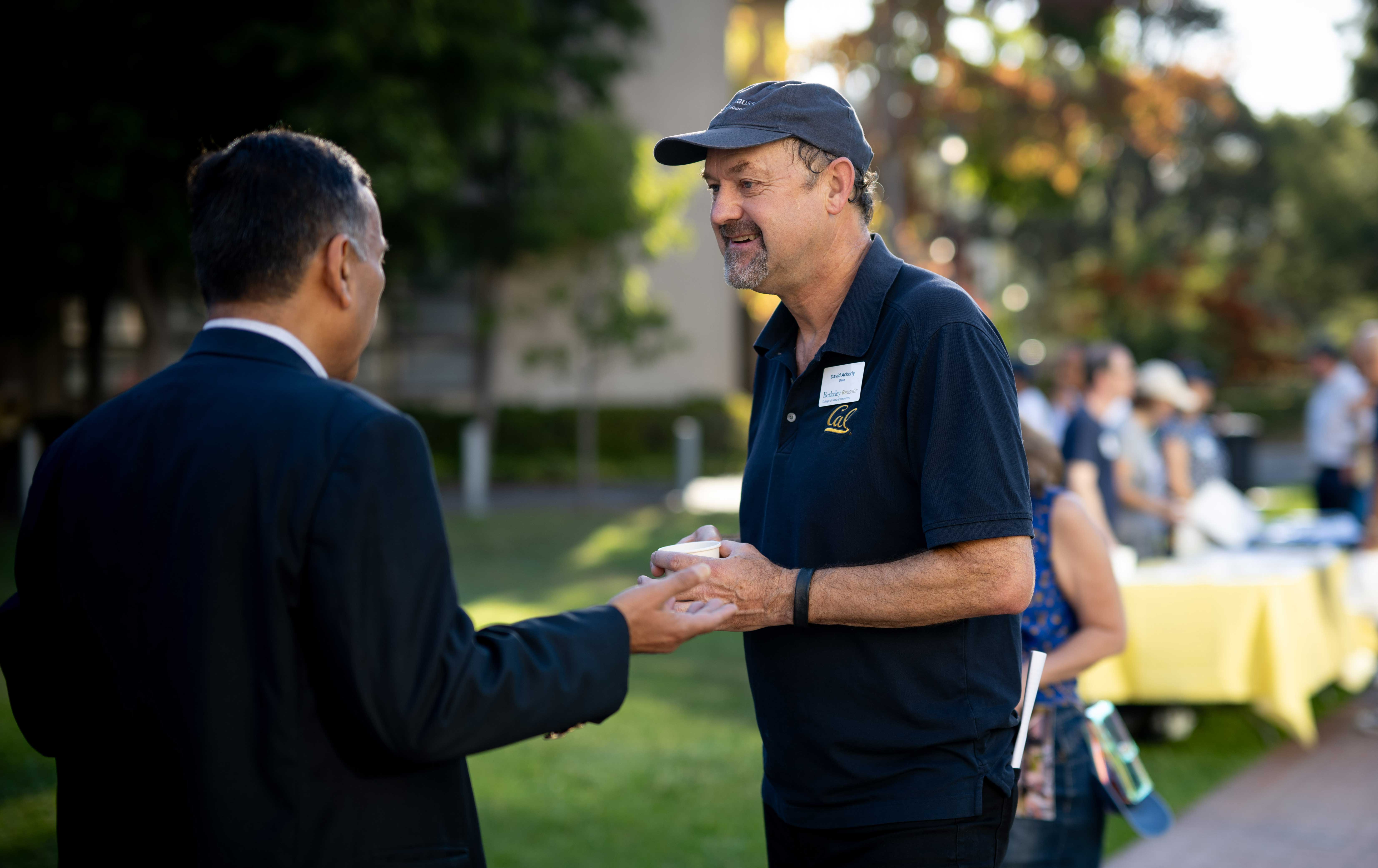 Dean Ackerly speaking to a man in a suit