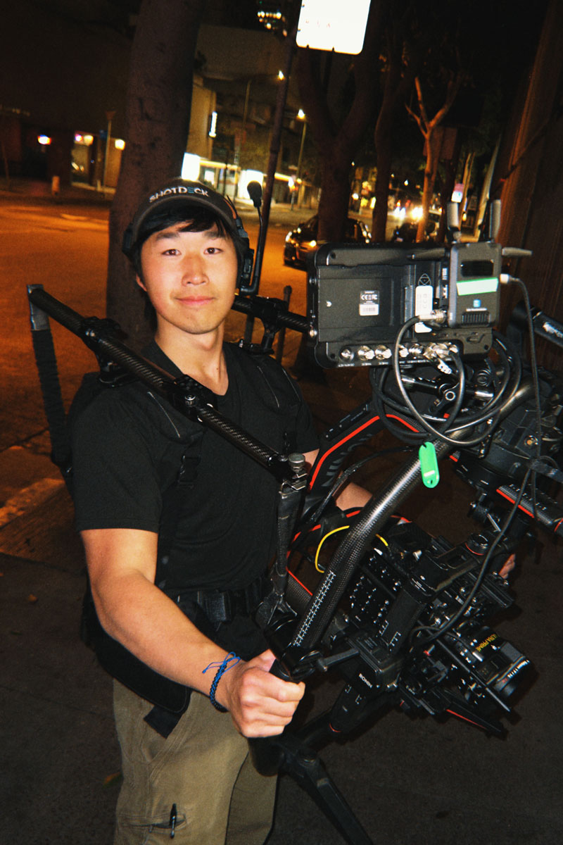 Behind the scene image of Zeng holding a camera