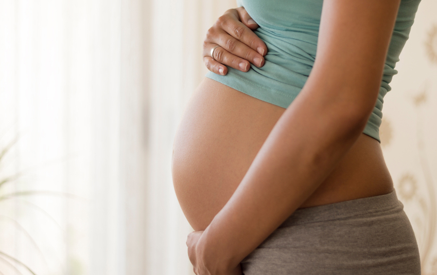 A closeup of the belly of a pregnant woman. 