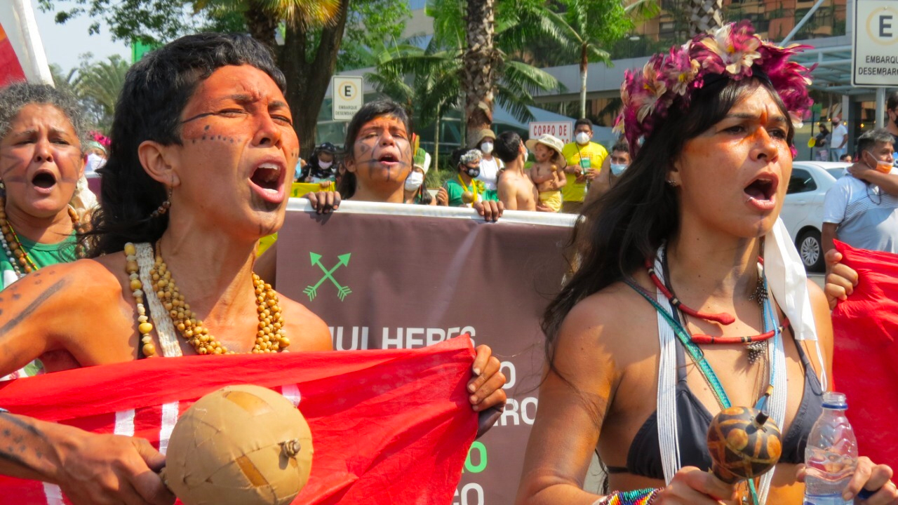 Two Indigenous women in Brazil shout during a demonstration