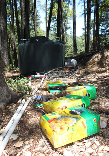 Discarded fertilizer boxes with water tank in the background