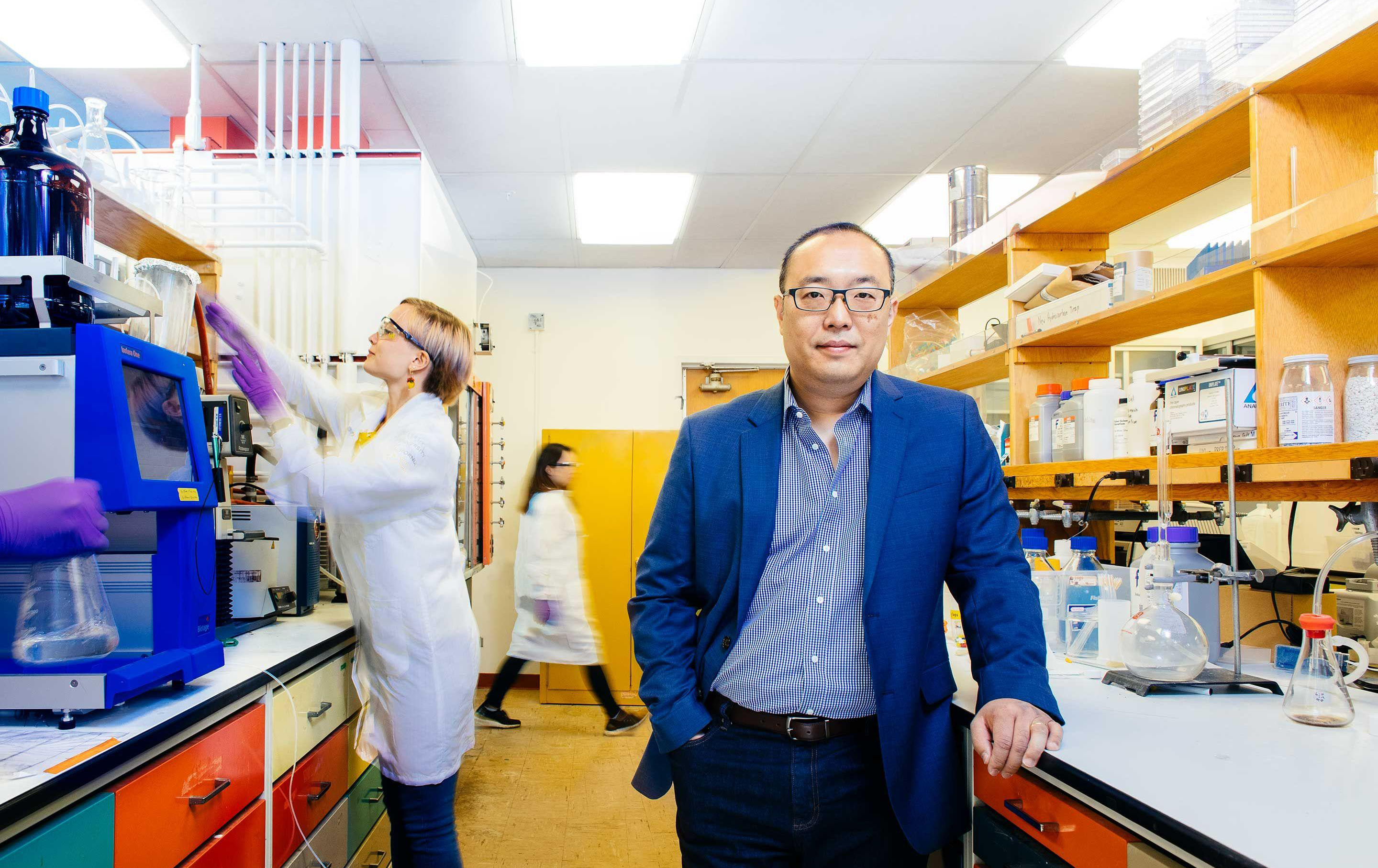 Daniel Nomura in his lab, other laboratory researchers are in the background