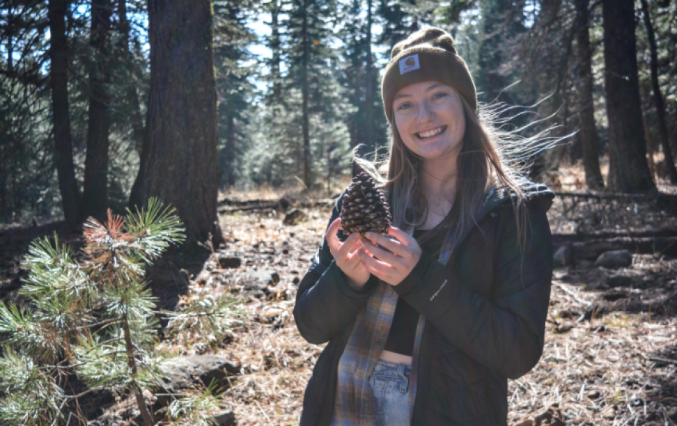 Ashlyn Olah in a forest holding a pine cone