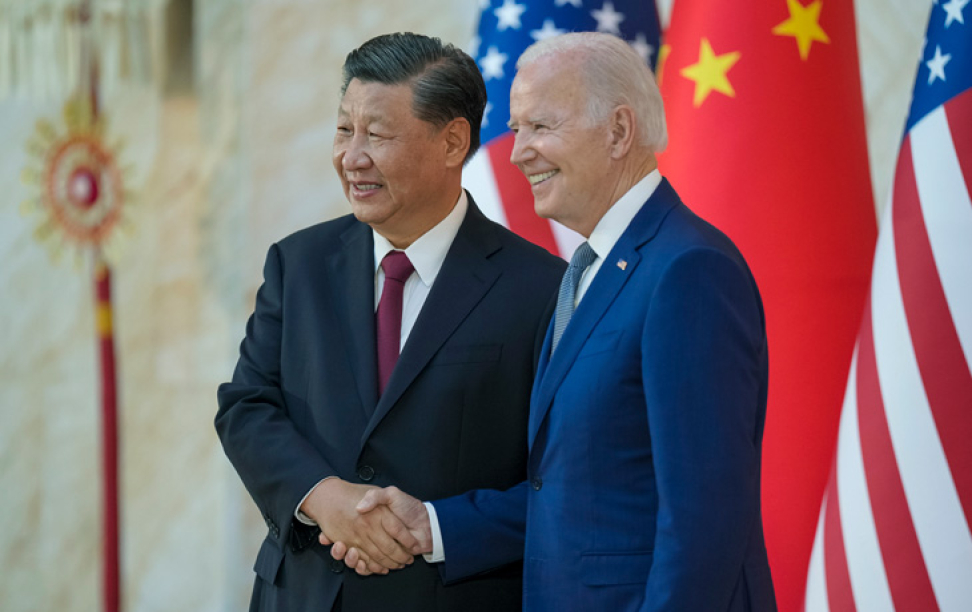 A photo of two men in suits shaking hands.