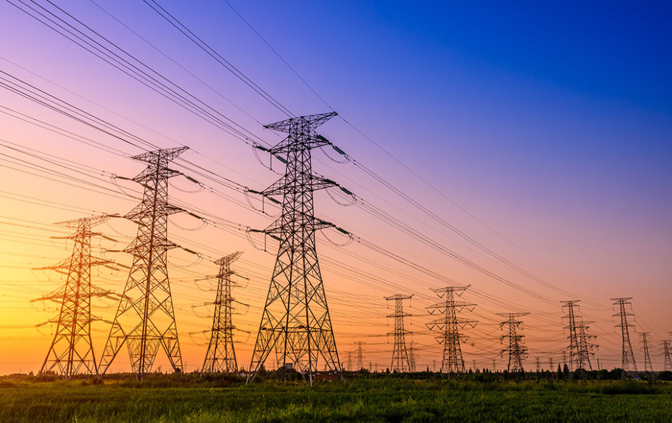 A sunset behind an electric transmission tower