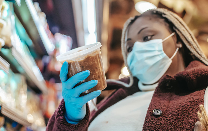 A woman in a mask shops at a grocery store.