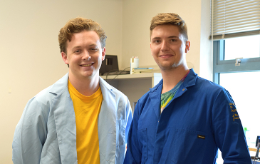 Photo of two students in a lab. 