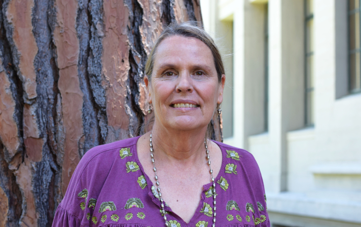 Lynn Huntsinger in a purple shirt in front of trees. 