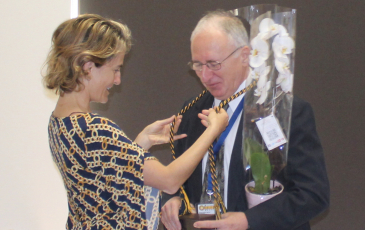 Professor Sofia Villas-Boas placing an honors cord around Professor Anastasios Melis' neck at honors research symposium