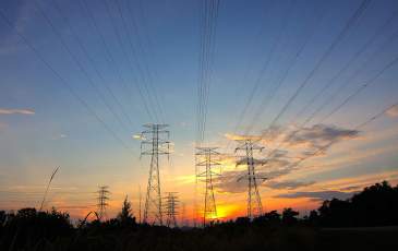 Large powerline towers against a sunset
